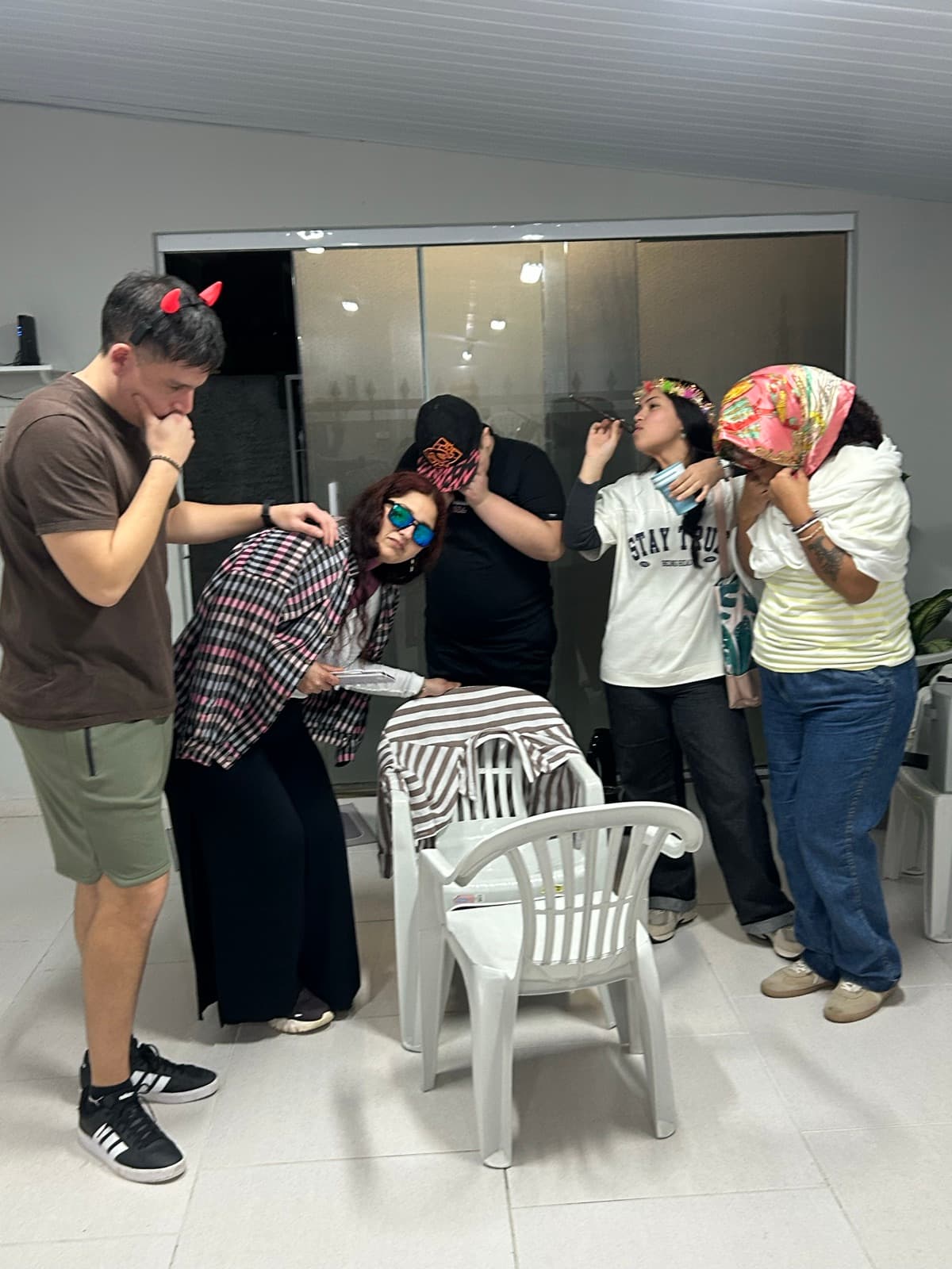 Participantes con pañuelos y accesorios componiendo personajes alrededor de una silla