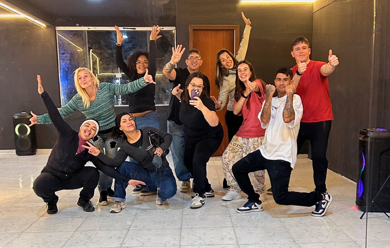 Grupo del taller frente al espejo de la sala, festejando con los brazos en alto